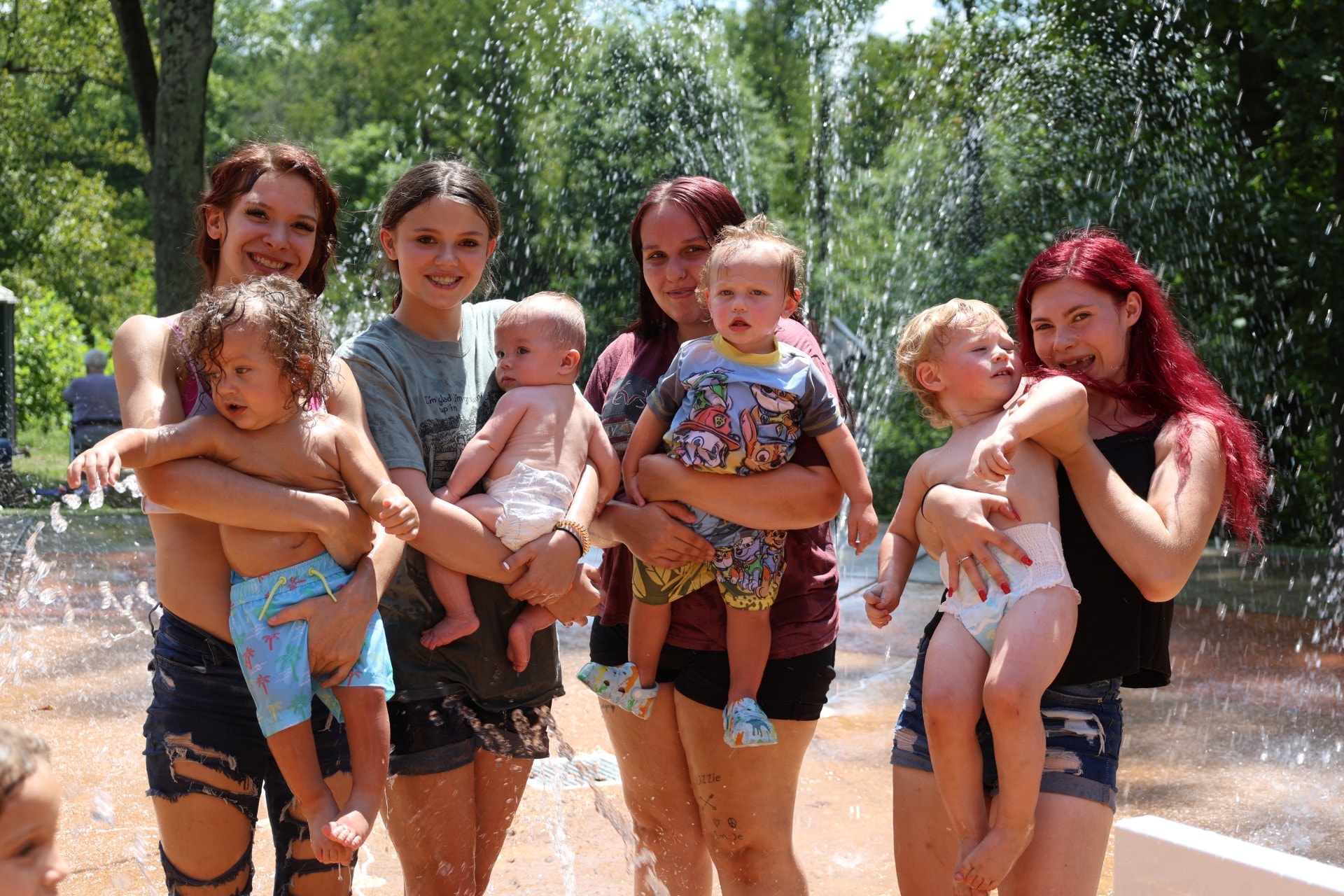 Teen parents with their young children at a splash pad — ELECT program